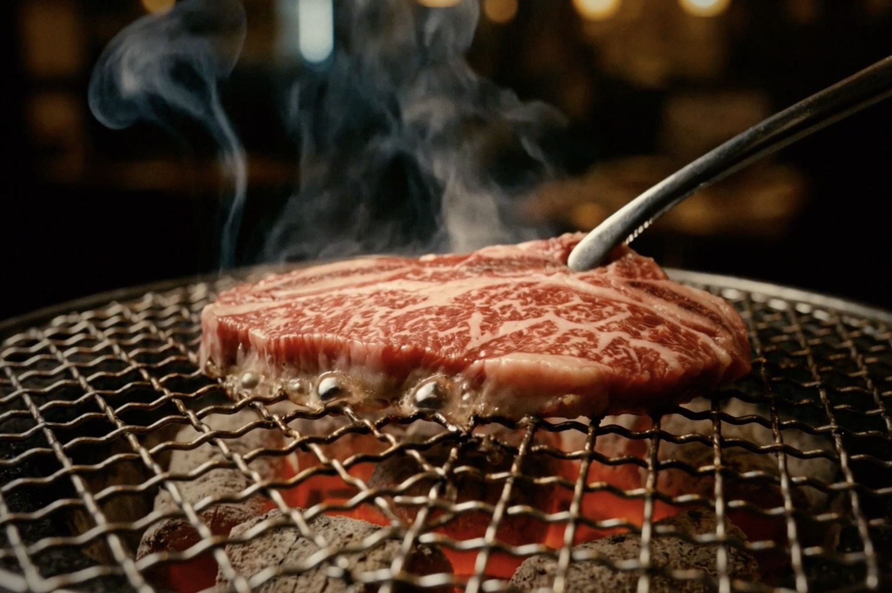 炭火で焼ける霜降り肉